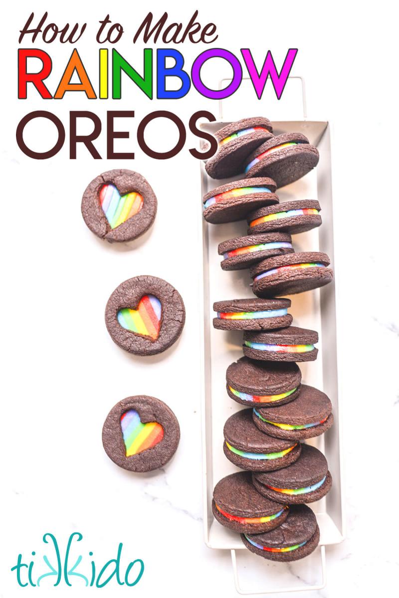 Homemade Oreo cookies with heart shaped cut-outs on top, filled with rainbow icing.  Text overlay reads "How to Make Rainbow Oreos."