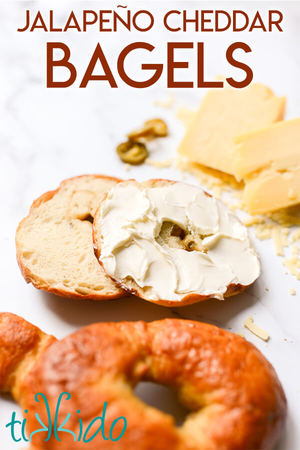 Jalapeño Cheddar Bagels sliced and spread with cream cheese, next to cheddar cheese and jalapeño slices, with text overlay reading "Jalapeño Cheddar Bagels".