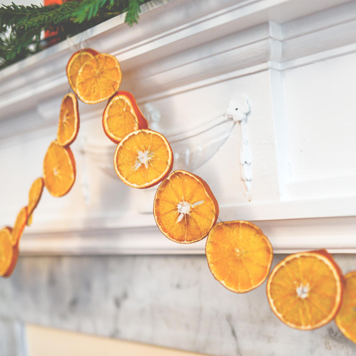 Closeup of a traditional Scandinavian Dried Orange Garland hung from a fireplace mantel.