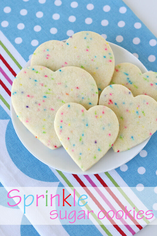 Sprinkle cut out sugar cookies on a white plate.
