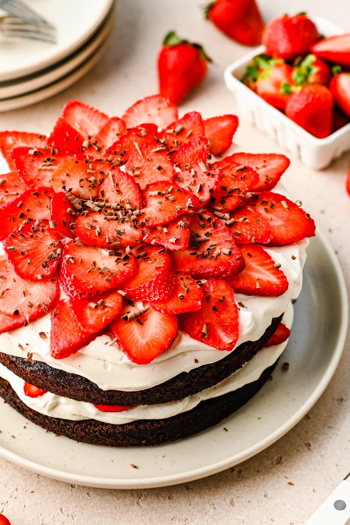 Easy layered chocolate, whipped cream, and strawberry cake on a white plate.