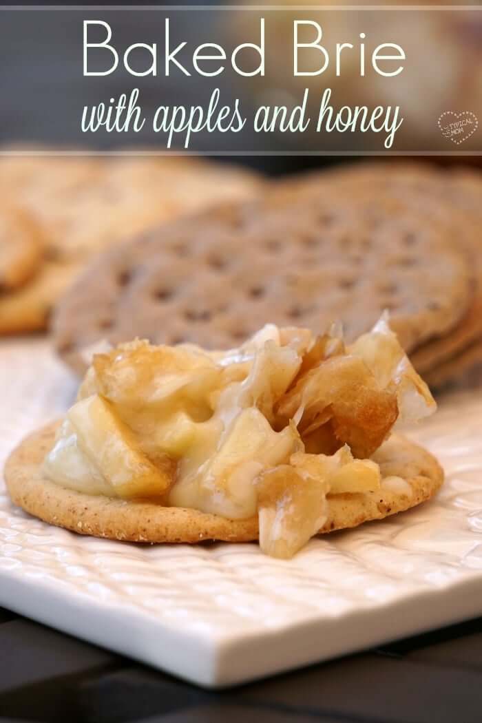 Baked brie with apples and honey, served on a round cracker.