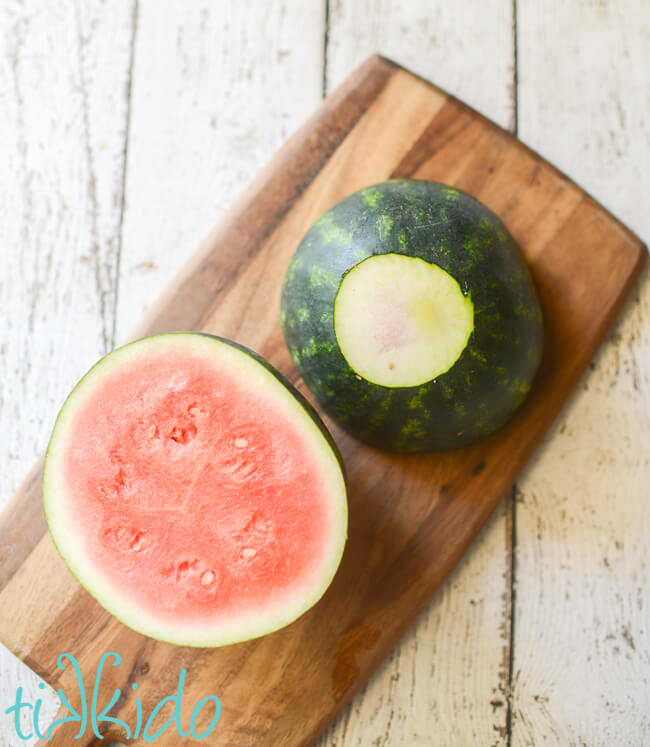 Small watermelon being cut to make individual serving bowls for 4th of July Fruit Salad.