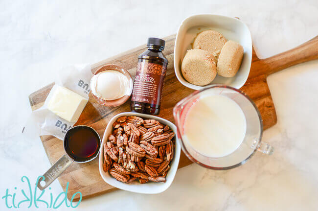 Ingredients for Praline Ice cream Topping on a wooden cutting board on a white marble surface.