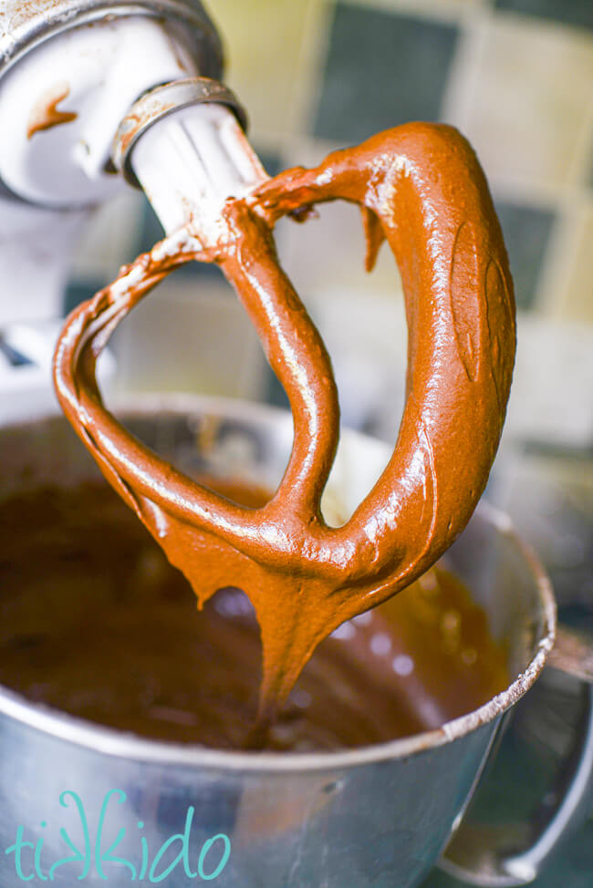 Whoopie pie cookie batter dripping from a kitchenaid mixer spatula.