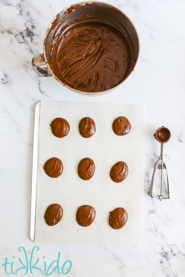 Chocolate Whoopie Pie batter scooped out on a parchment lined cookie sheet.