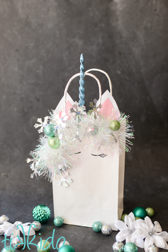 Christmas unicorn gift bag on a black chalkboard background.