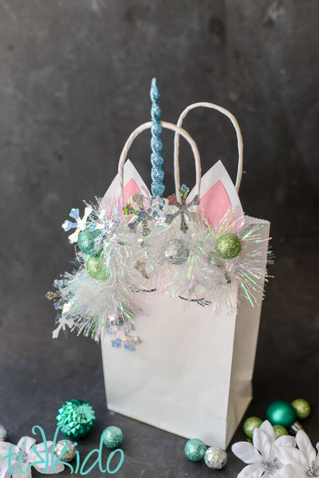 DIY Christmas gift bag that looks like a unicorn on a black chalkboard background.