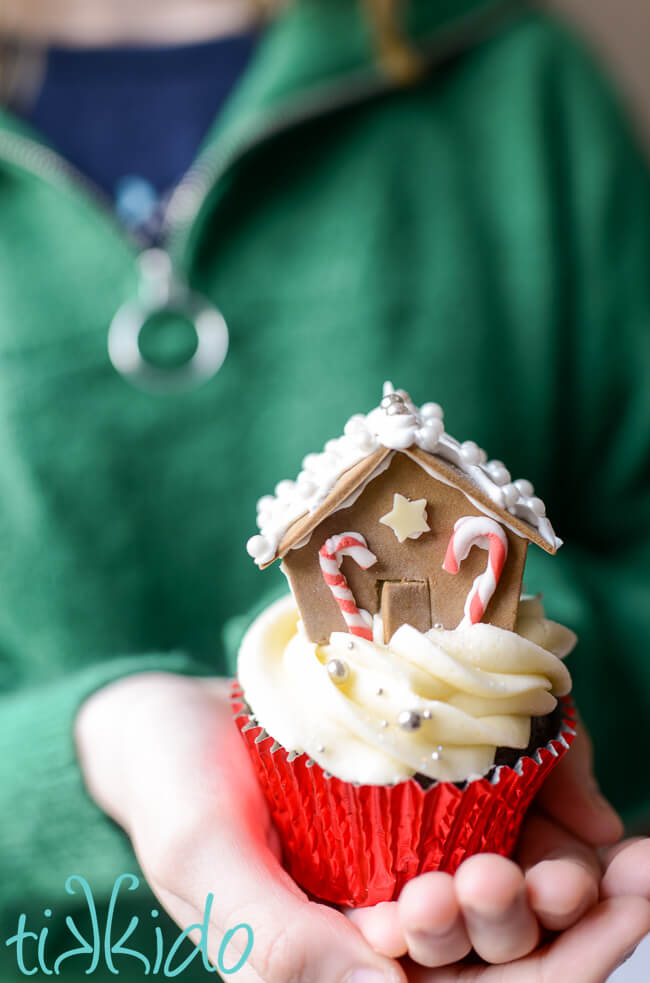 Christmas cupcake topped with a miniature gingerbread house made from gum paste.