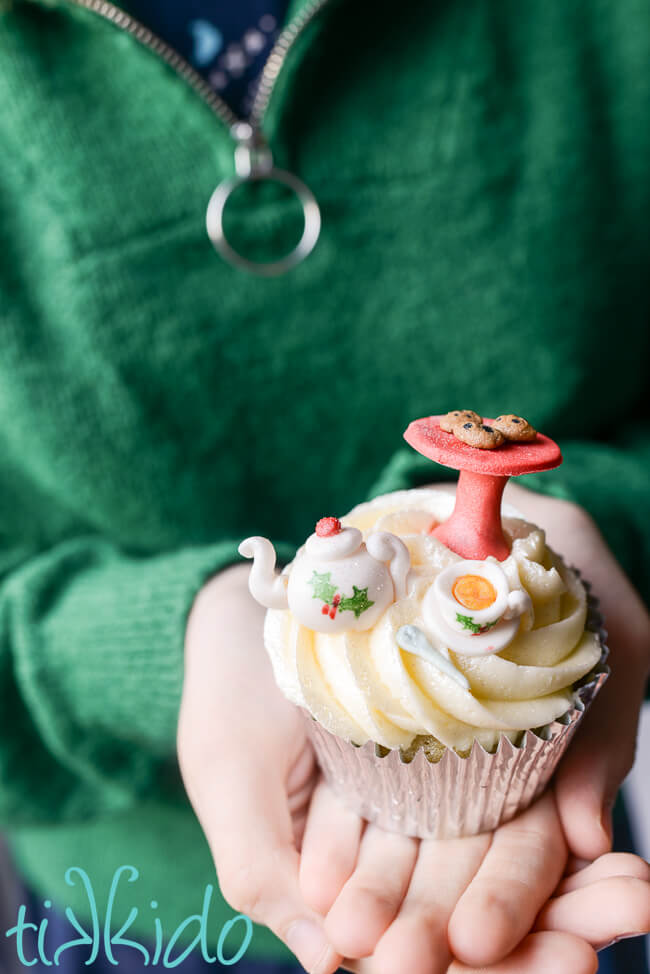 Christmas cupcake decorated with a gum paste tea set, including a miniature cake plate with cookies.