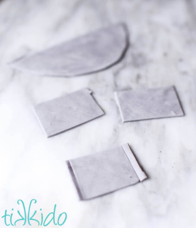 Gum paste being cut and shaped into miniature cookie sheets for Christmas Baking Cupcake Toppers