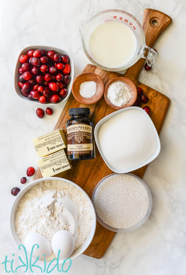 Ingredients for cranberry muffins recipe on a wooden cutting board.