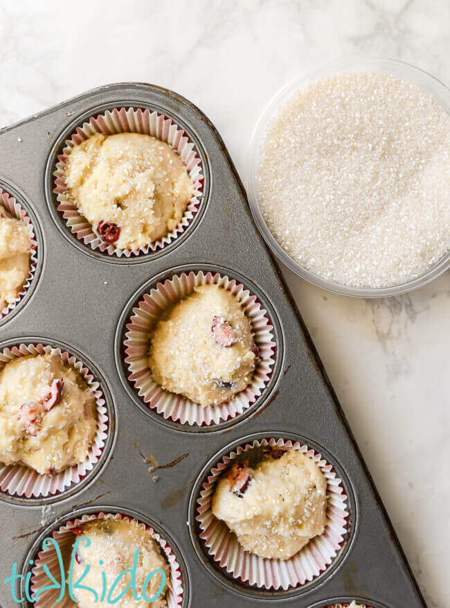 Cranberry muffins batter scooped into lined muffin tins.