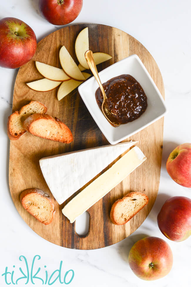 Ingredients for Apple, Fig, and Brie Crostini on a wooden cutting board.