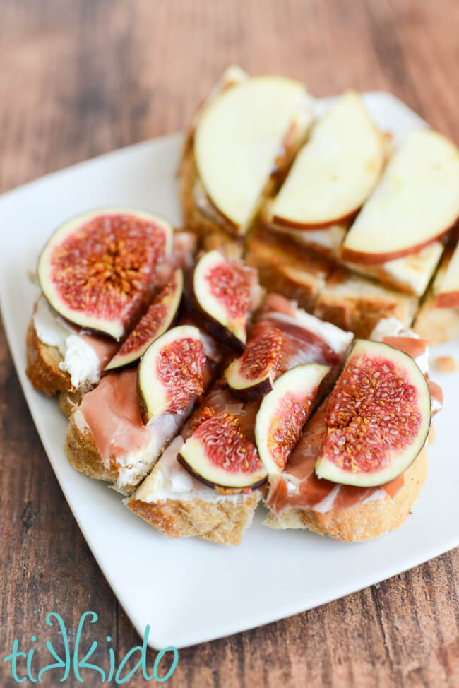 Fig, Prosciutto, and Mascarpone Bruschetta and Apple, Fig, and Brie bruschetta on a square white plate.