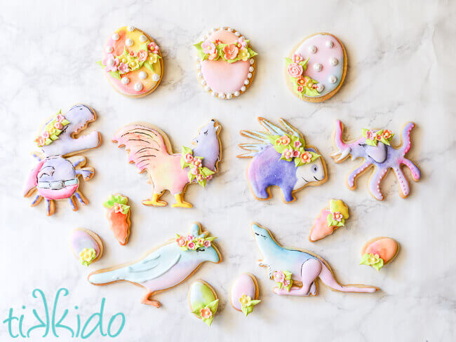 GISHWHES mascot sugar cookies in pastel watercolor colors for Easter, with royal icing flower crowns, on a white background.