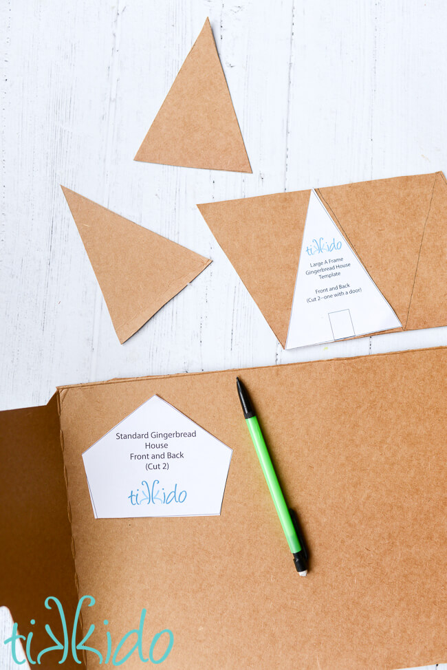 Cardboard being cut into gingerbread house shapes to make a gingerbread house Christmas garland.