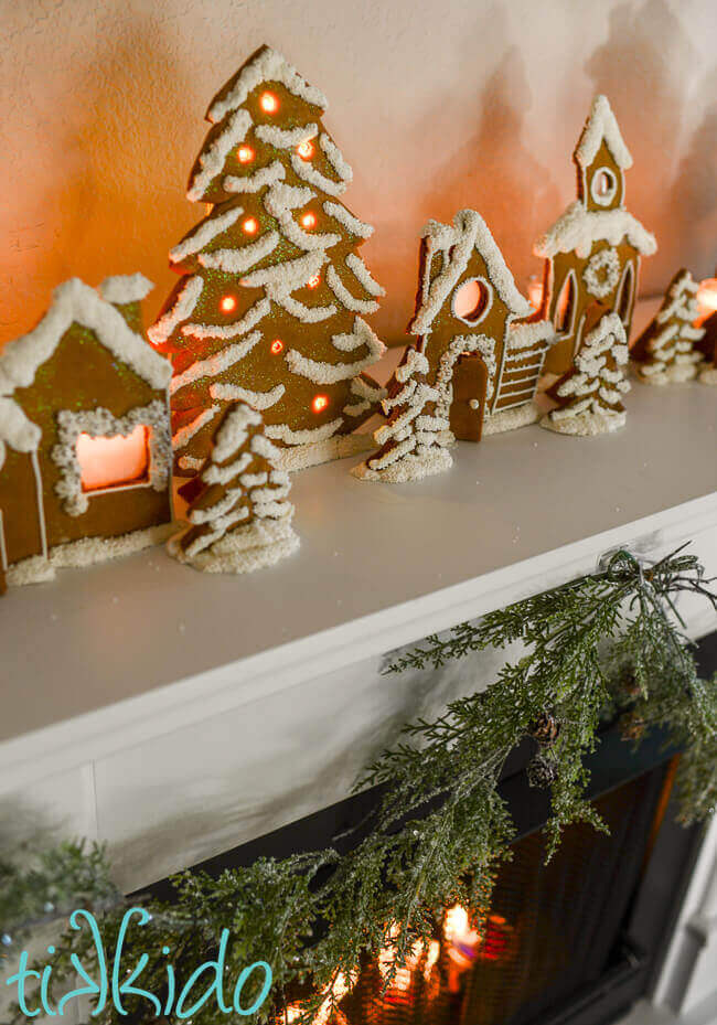 House shaped gingerbread candle holders decorated with white icing and sprinkles.