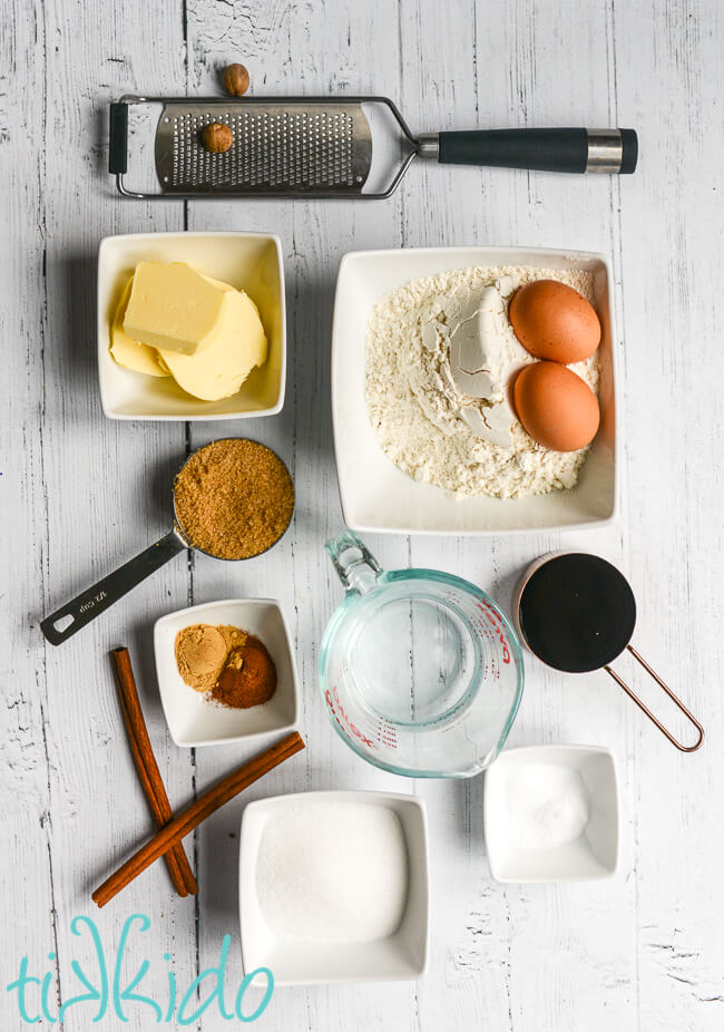 Ingredients for a recipe for gingerbread loaf on a white wooden surface.