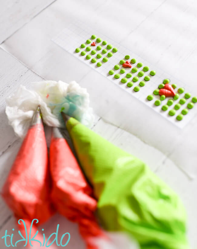 Grinch Candy Buttons being piped on wax paper.