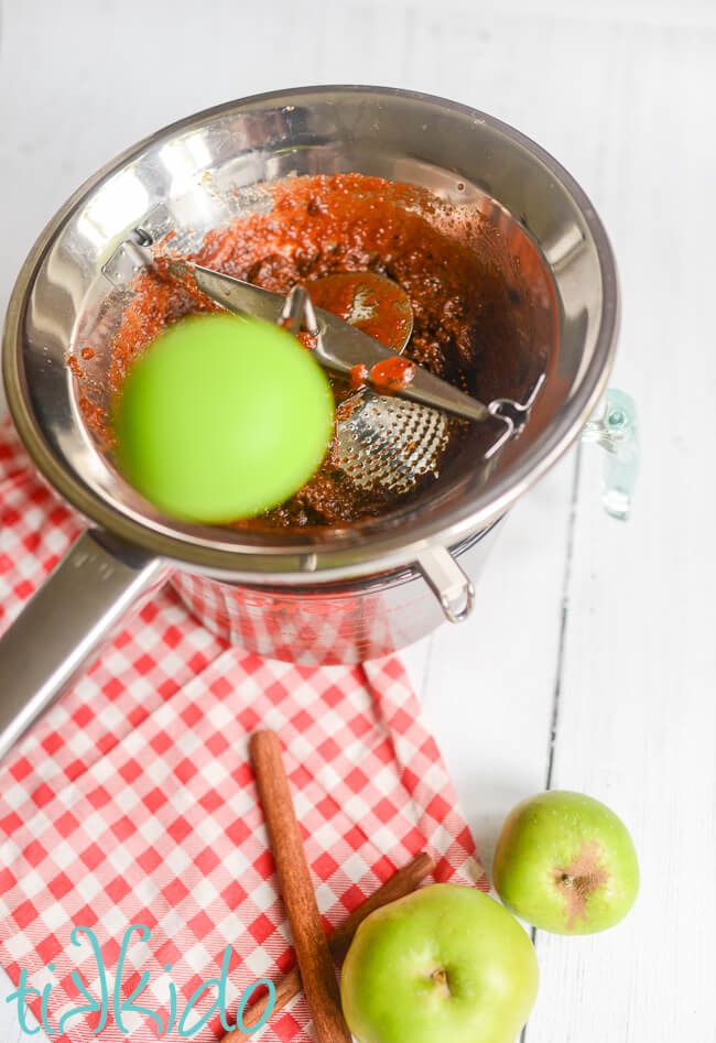 Cooked apples being processed in a food mill to make Instant Pot Apple Butter Recipe.