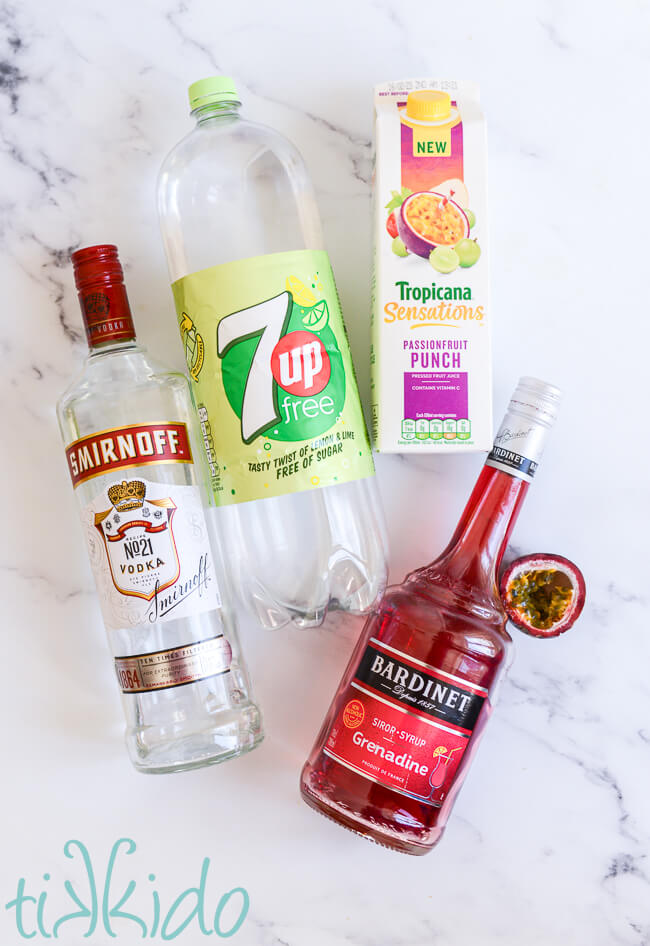 Ingredients for a passionfruit punch cocktail on a white marble surface.