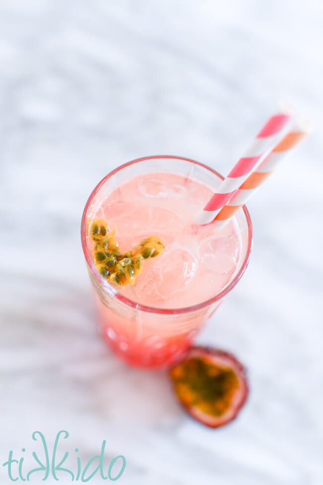 Passionfruit seeds floating on top of a passionfruit punch cocktail.