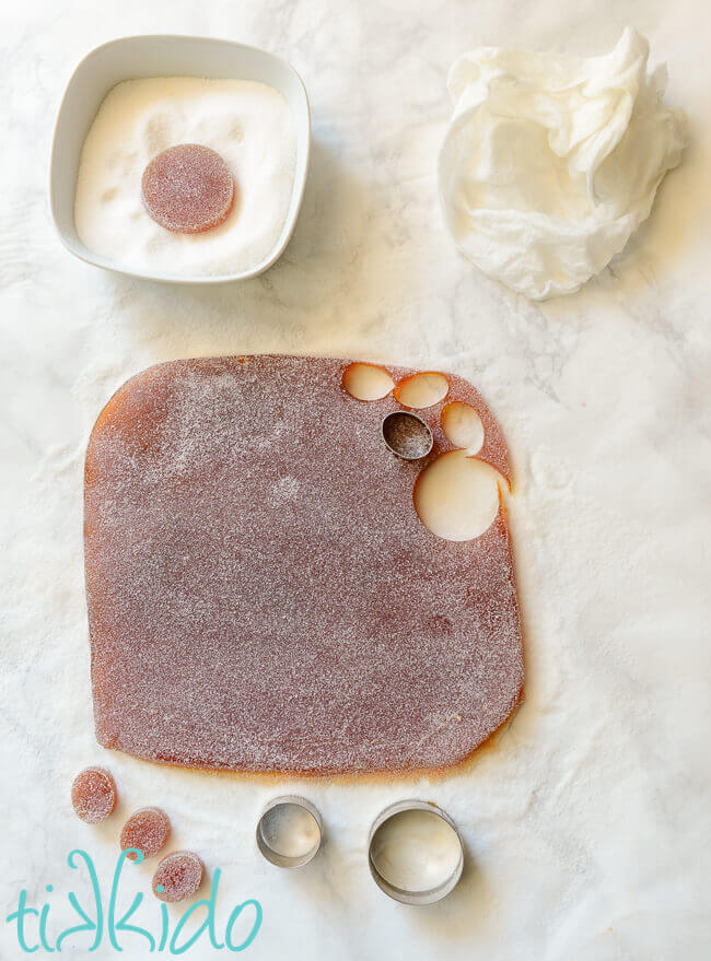 Peach Pate de fruit being cut into shapes on a white marble surface.