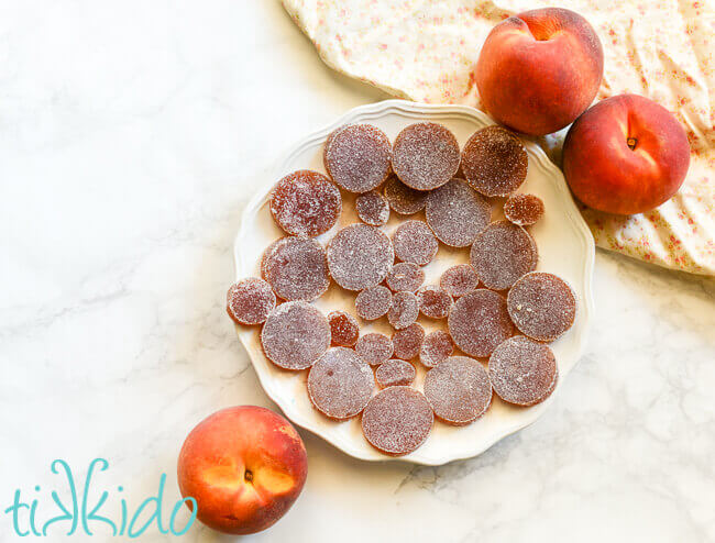 Plate full of peach Pate de fruit surrounded by fresh peaches