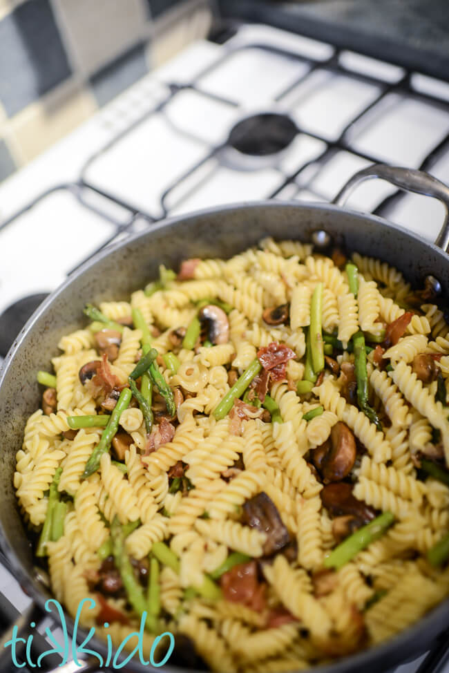 Prosciutto, asparagus, and mushroom pasta in a large saucepan.
