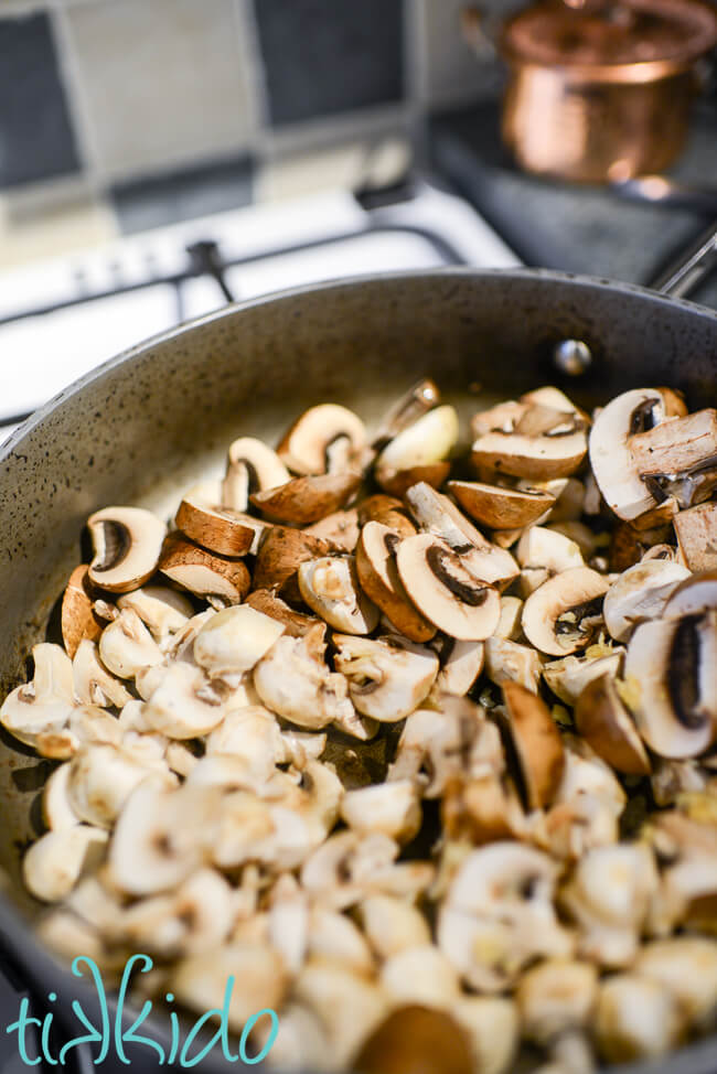 Mushrooms and garlic in a pan for making prosciutto, mushroom, asparagus pasta recipe.
