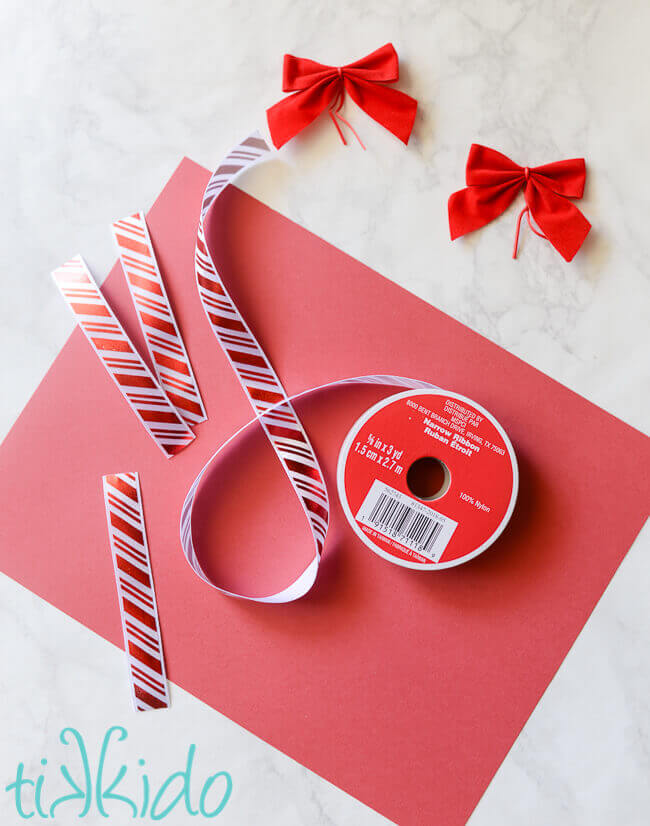 Materials for making peppermint striped Christmas tree mantel decorations out of ribbon and paper.