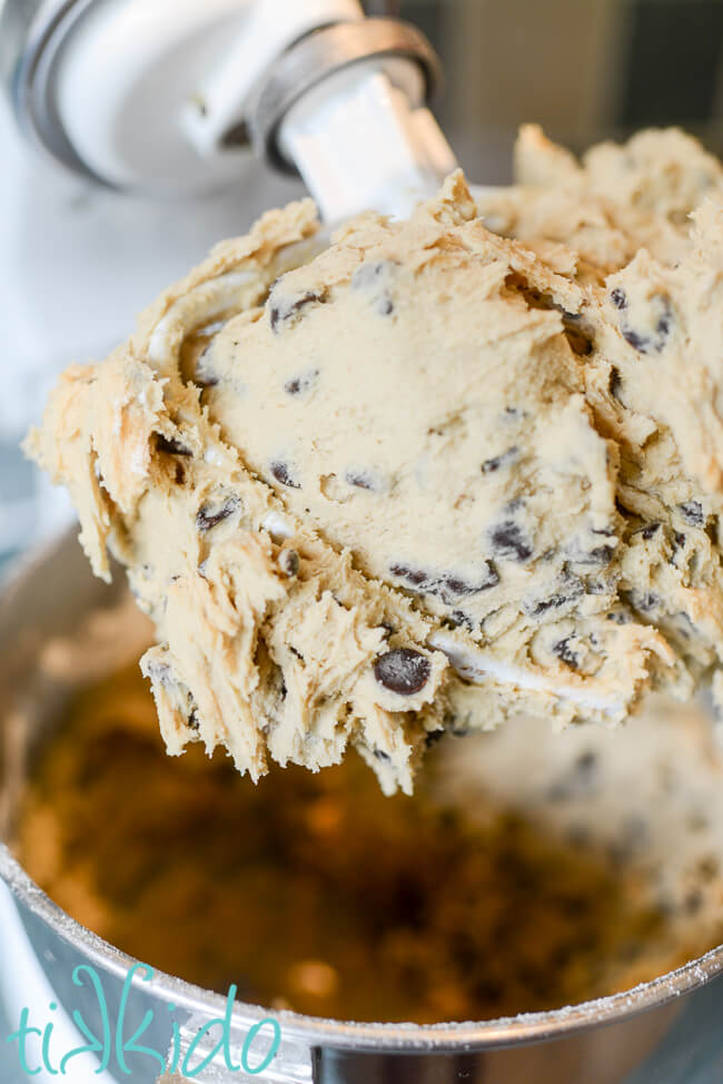 Chocolate chip cookie dough in a Kitchenaid mixer for making a giant pizza cookie.