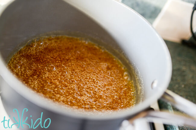 Sugar, water, and corn syrup being caramelized to make homemade salted caramels recipe.