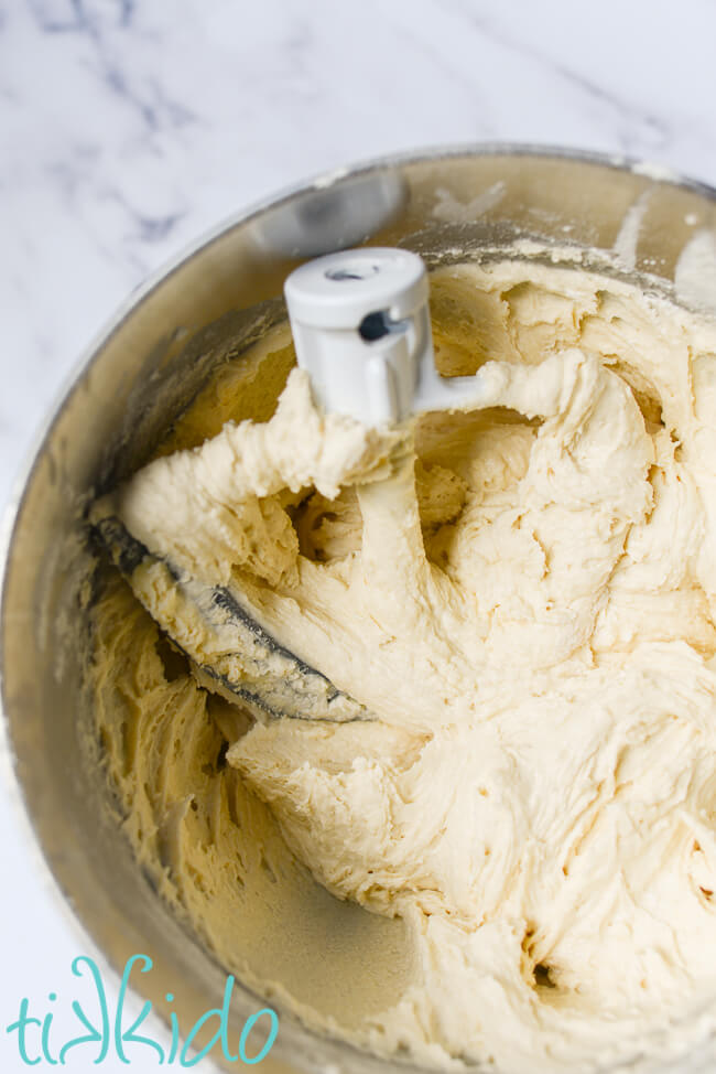 Soft sugar cookie dough in a silver mixing bowl.