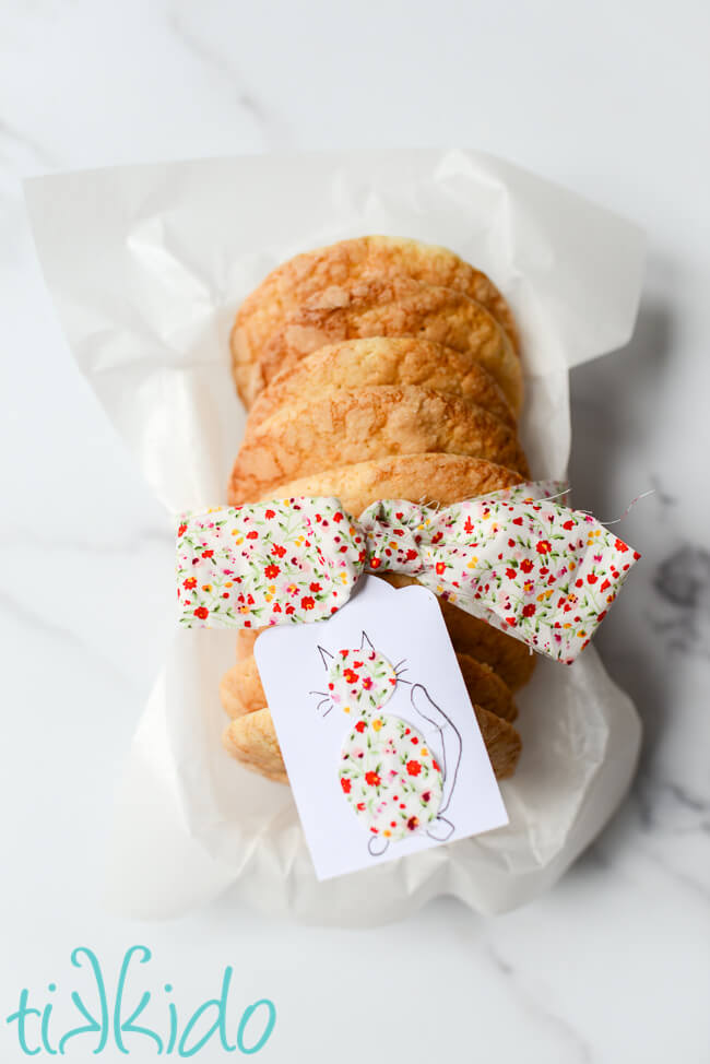 Soft sugar cookies packaged up to give as a gift with a fabric ribbon bow and matching gift tag.