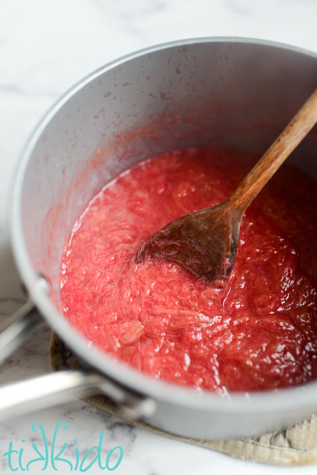 Saucepan of stewed rhubarb with a wooden spoon.