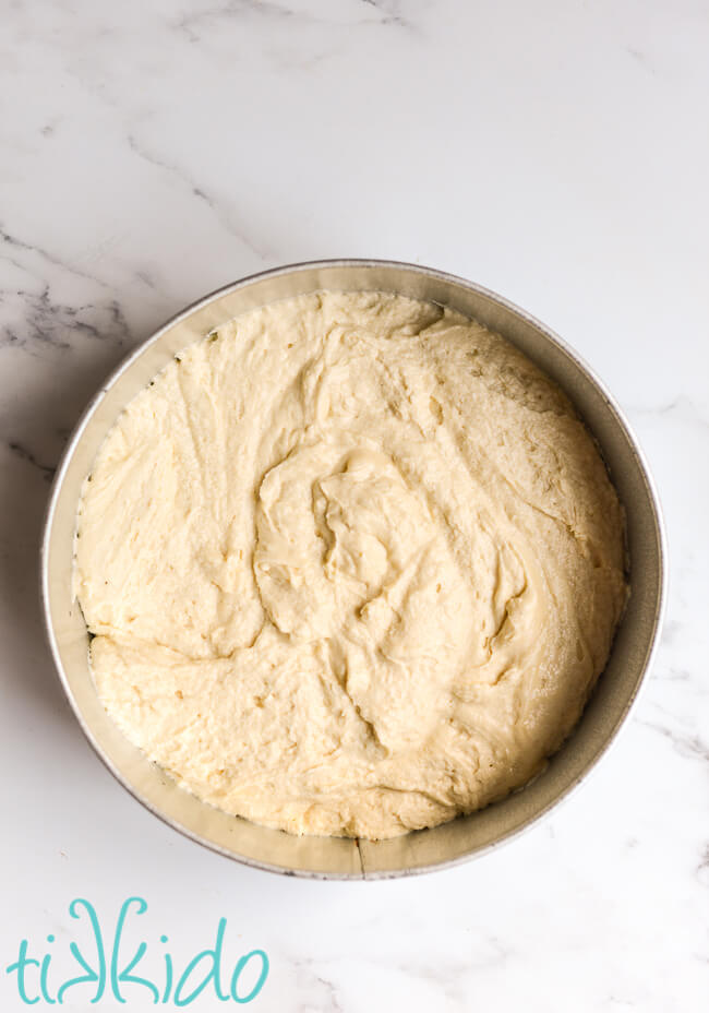 Vanilla Butter Cake batter in a 12" round baking pan on a marble surface.