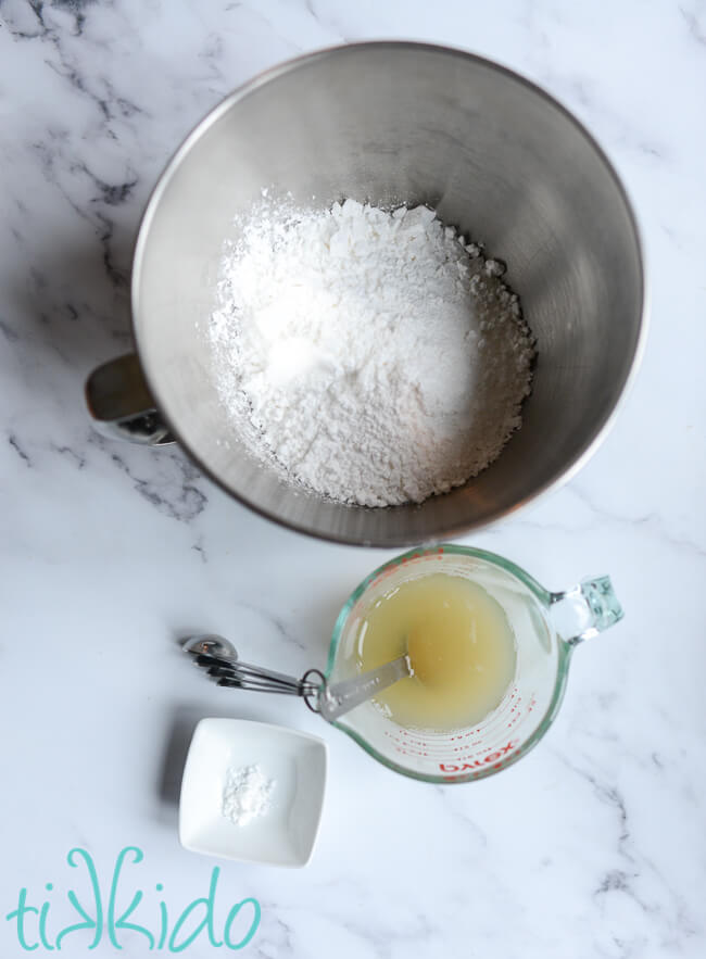 Ingredients for vegan royal icing on a marble surface.