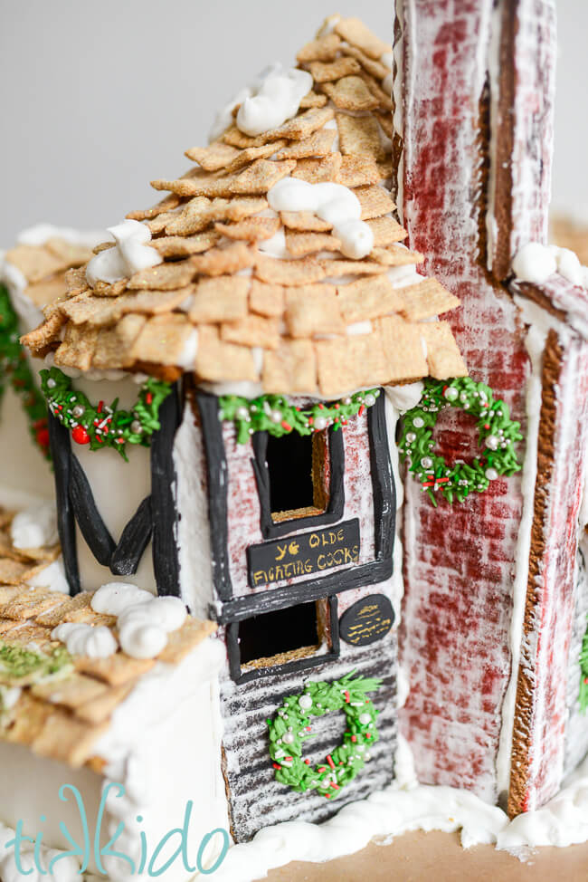 Detail of the signs and chimney on the side of the gingerbread Ye Olde Fighting Cocks.