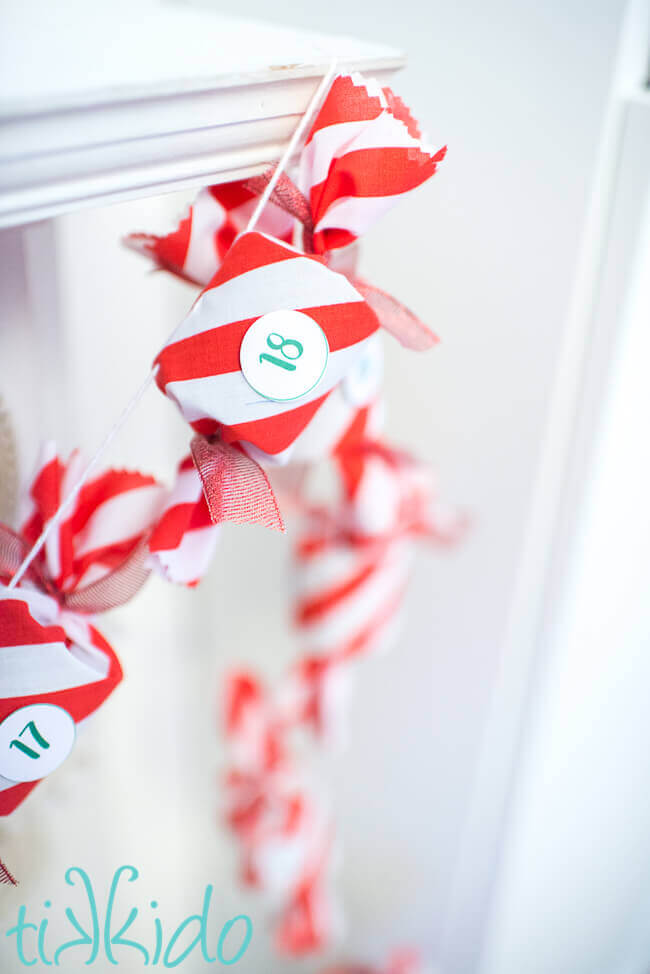 DIY Advent Calendar garland hanging on a white fireplace mantel.