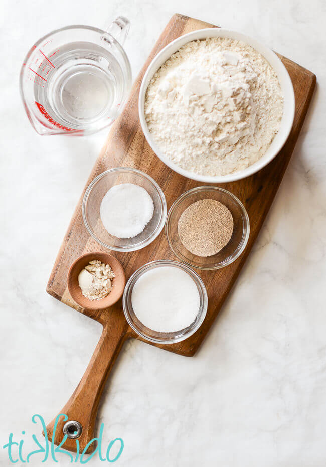 Ingredients for the best homemade bagel recipe on a wooden cutting board.