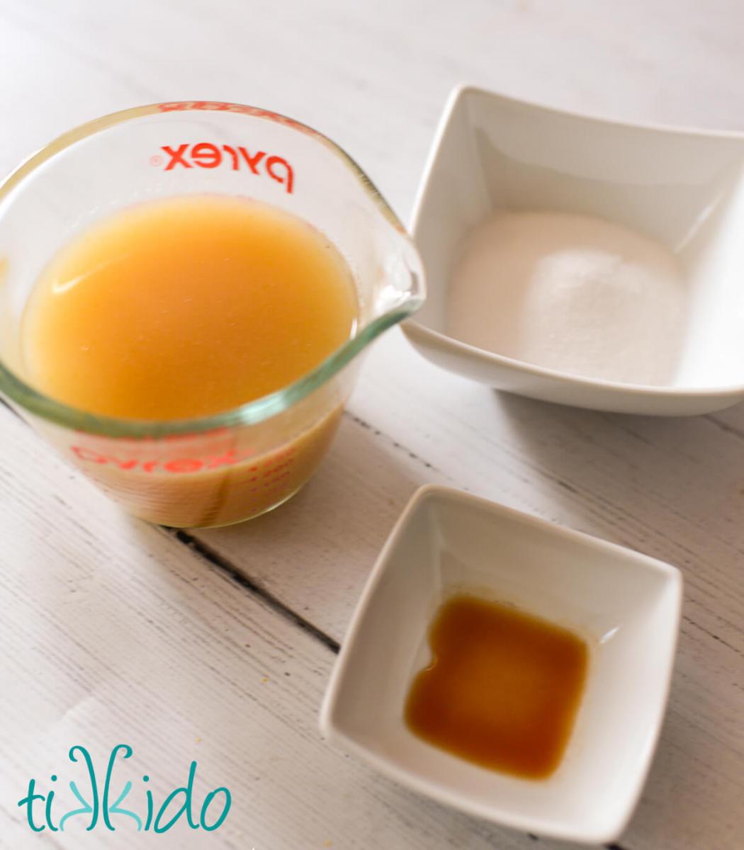 Ingredients for apple cider glaze on a white wooden surface.