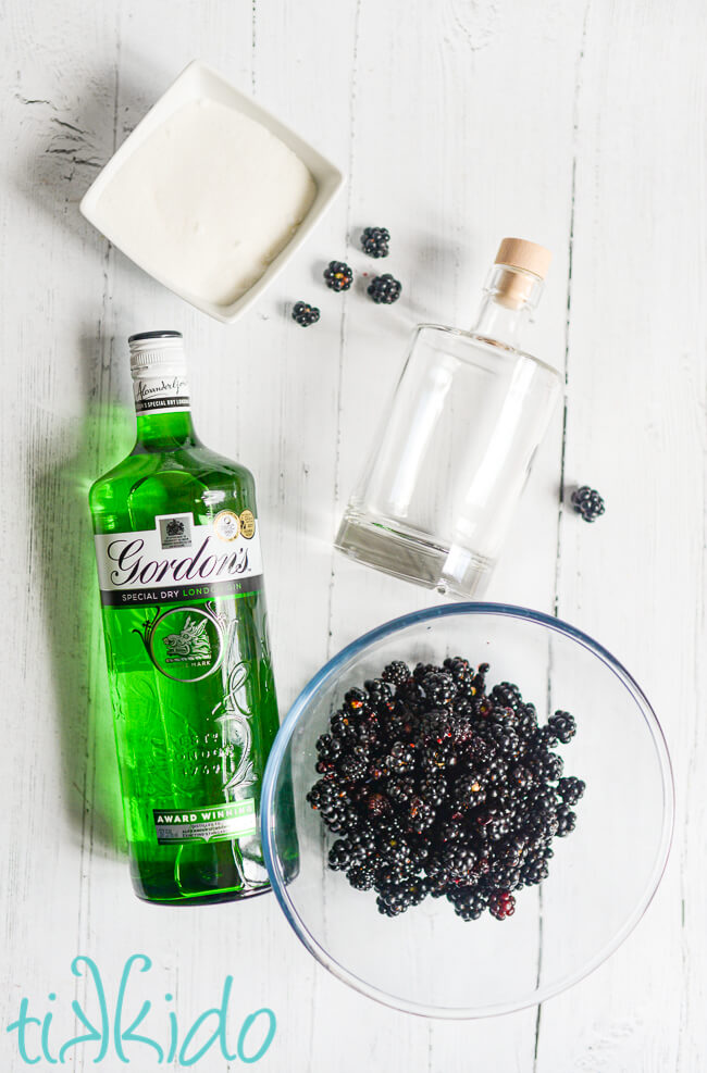 Ingredients for Blackberry Gin Recipe on a white wooden surface.