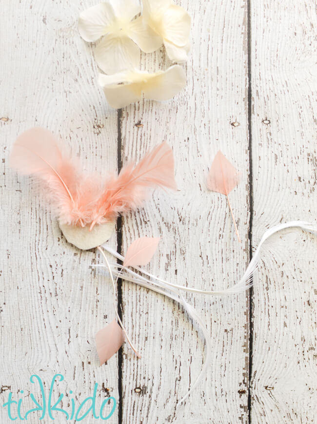 Gift toppers for BOHO gift wrapping being assembled with feathers, felt, and silk flowers.