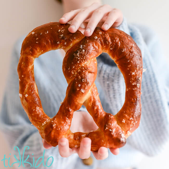 Large Auntie Anne's pretzel made with a bread machine held between two hands.