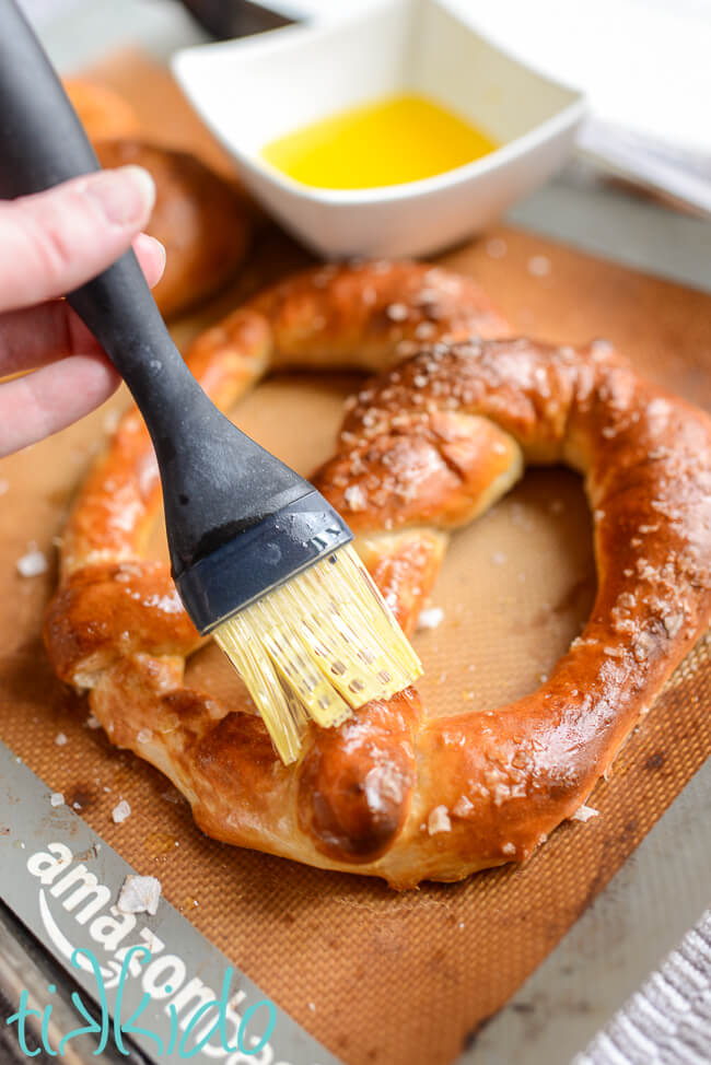 Butter being brushed on Auntie Anne's copycat pretzel after baking.