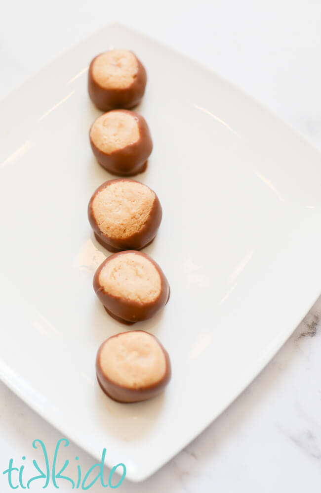 Buckeye Candies in a line on a white plate.