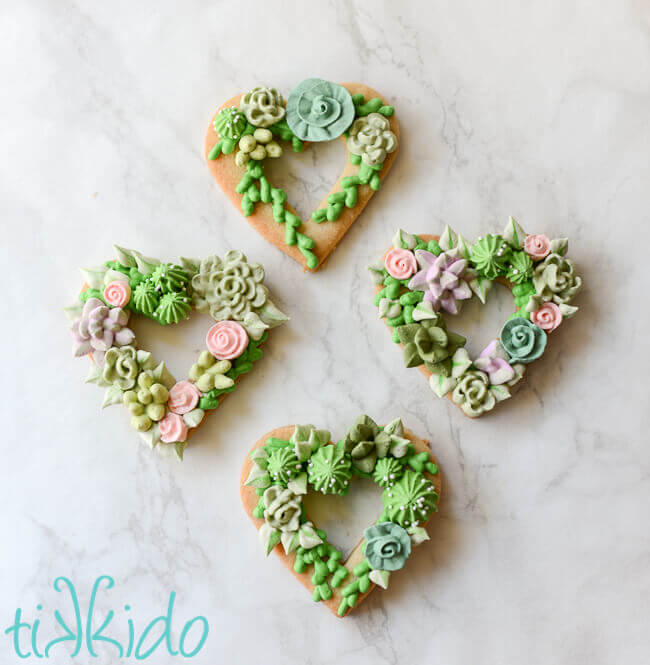 Heart shaped sugar cookies, covered in piped royal icing succulents.