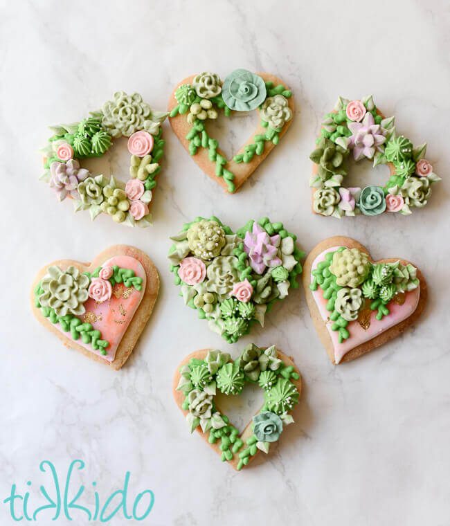 Heart shaped sugar cookies, covered in piped royal icing succulents.